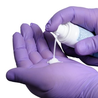 idra®care Idrogel Anwendung auf Handschuh zur Demonstration der Konsistenz