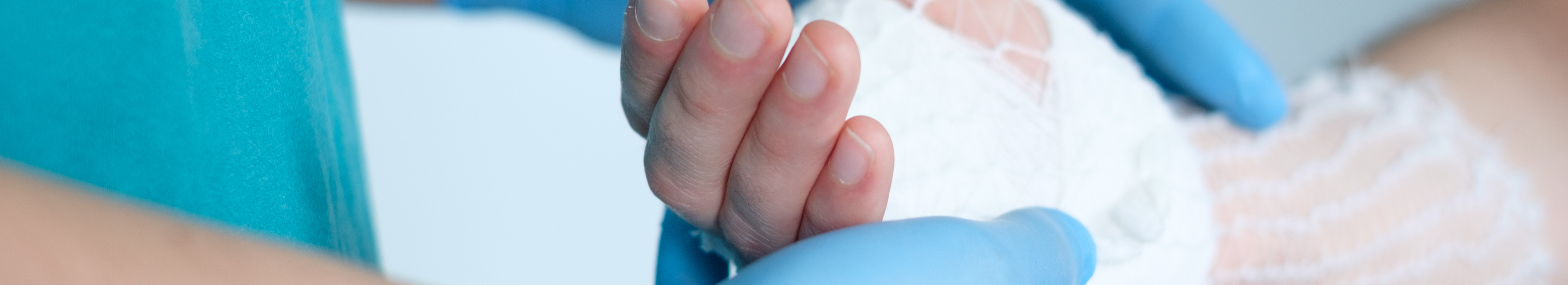 Doctor holding a hand tied with tubular net dressing