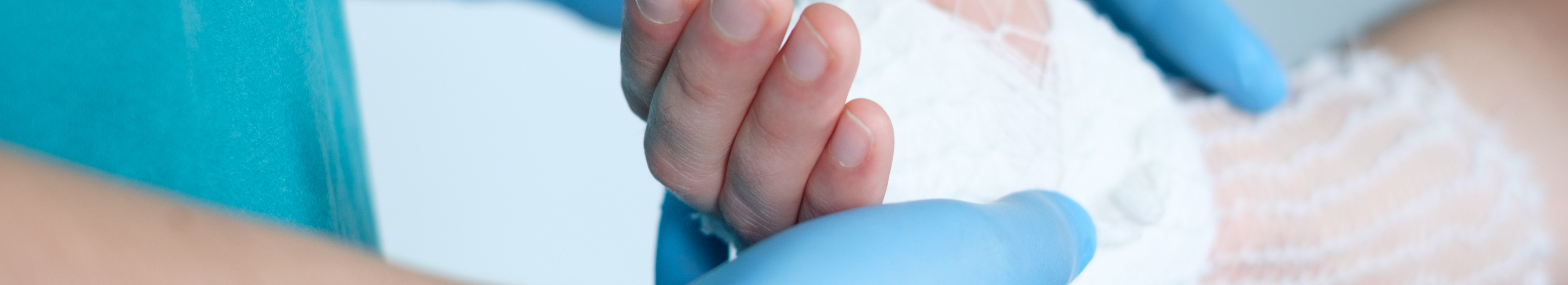 Médecin tenant la main sur laquelle on pose une bande avec filet tubulaire