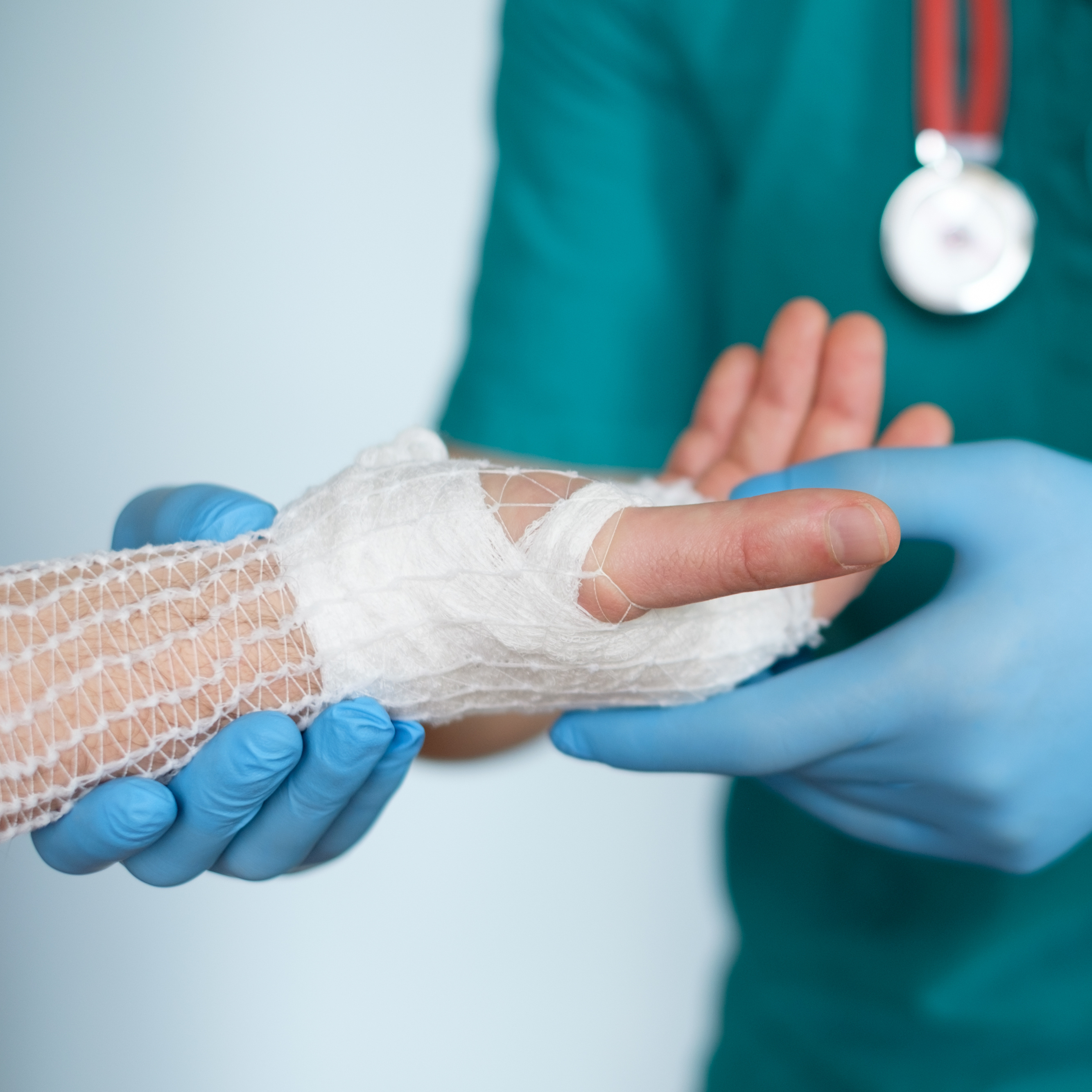 Médico sosteniendo una mano con un vendaje tubular de malla