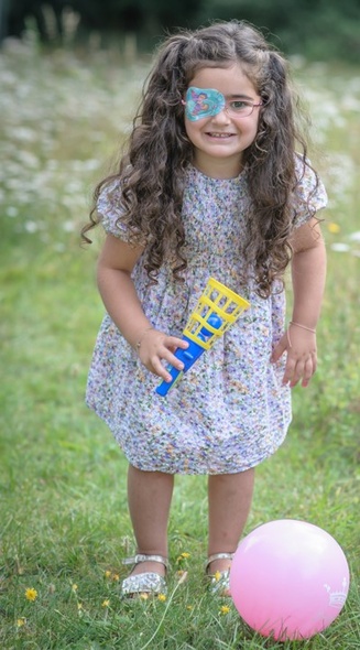 Girl with an ORTOPAD® eye patch with butterfly design plays