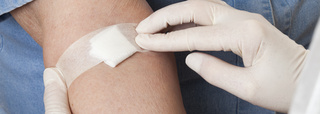 A swab is fixed in place on arm after blood sample is taken.