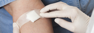 Se fija una compresa en el brazo después de la extracción de sangre.