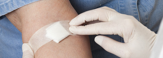 Se fija una compresa en el brazo después de la extracción de sangre.