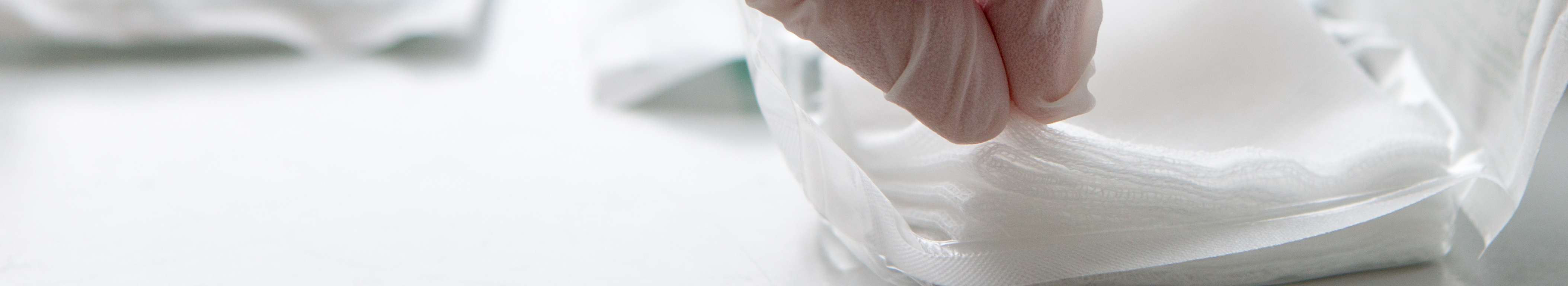 Sterile swabs being removed from packaging with gloves