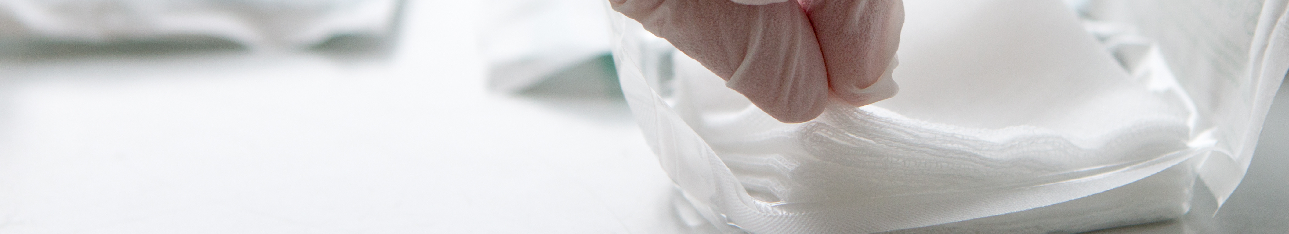 Sterile swabs being removed from packaging with gloves