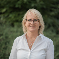 Photo de notre gérante Rita Brüggemann avec arrière plan vert