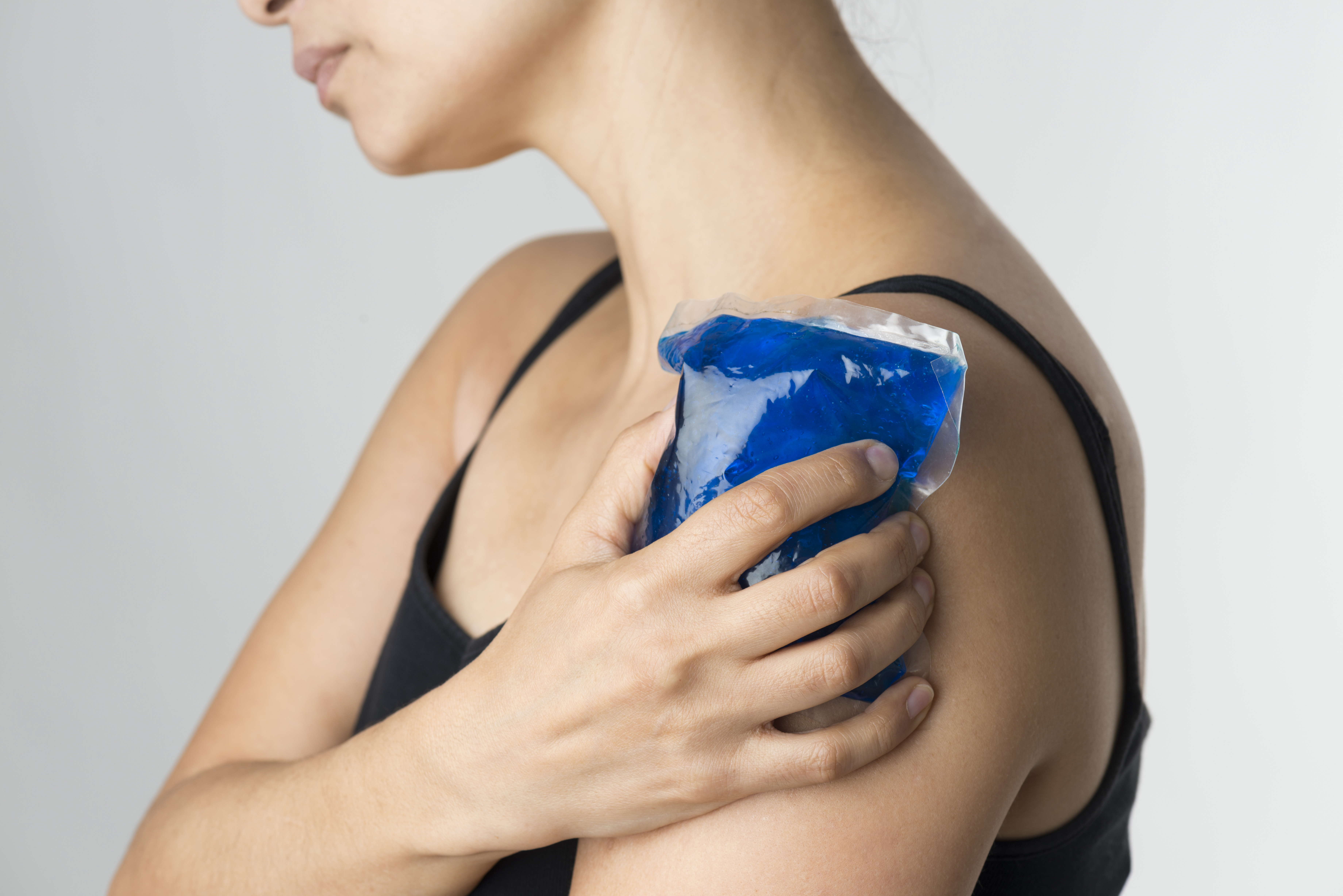 Woman cooling her shoulder/upper arm with a cold compress